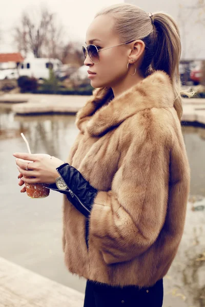 Sexy loira mulher vestindo luxuoso casaco de pele e óculos de sol — Fotografia de Stock