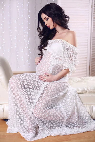 Beautiful pregnant woman with dark hair wearing lace dress — Stock Photo, Image