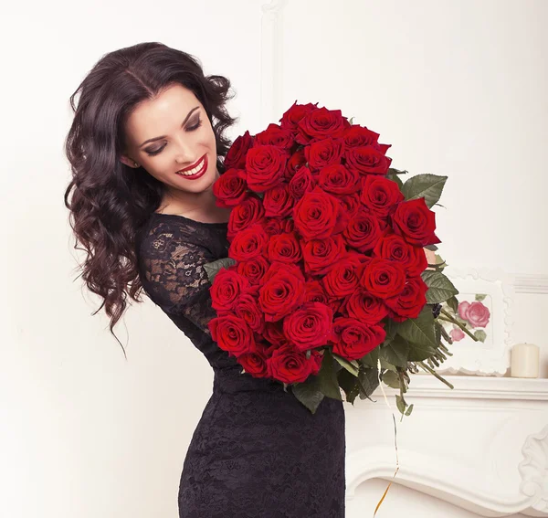 Brunette woman in elegant lace dress, holding a big bouquet of r — Stock Photo, Image