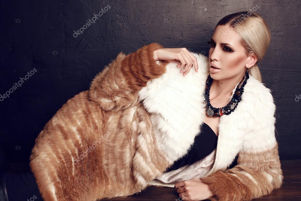 gorgeous woman with blond hair in luxurious fur coat 