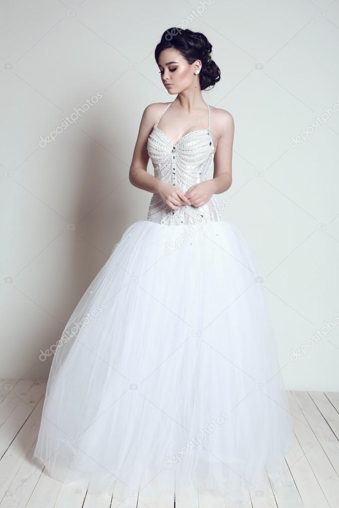 elegant bride with dark hair in luxurious wedding dress  