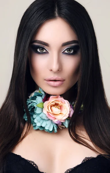 Mulher sensual com cabelo preto liso com maquiagem brilhante e colar de flores — Fotografia de Stock