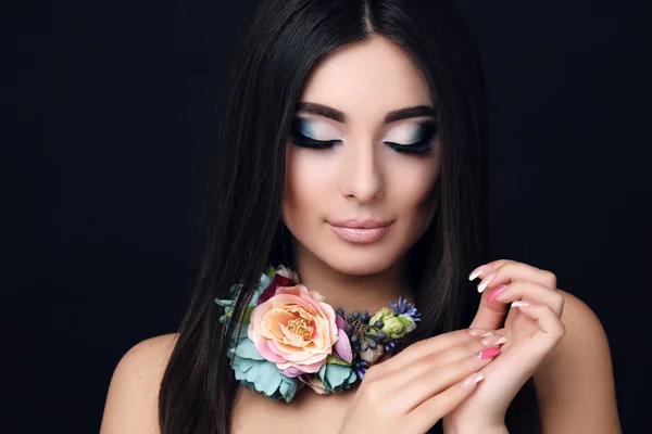 Donna sensuale con capelli neri dritti con trucco luminoso e collana di fiori — Foto Stock