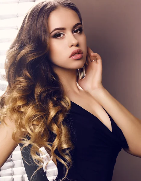 Bela jovem com cabelo encaracolado luxuoso em vestido preto elegante — Fotografia de Stock
