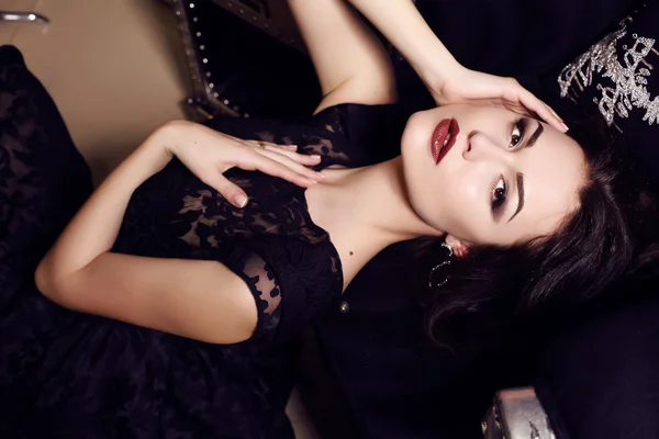 Piękna kobieta w elegancka czarna sukienka pozowanie w luksusowe wnętrza — Zdjęcie stockowe