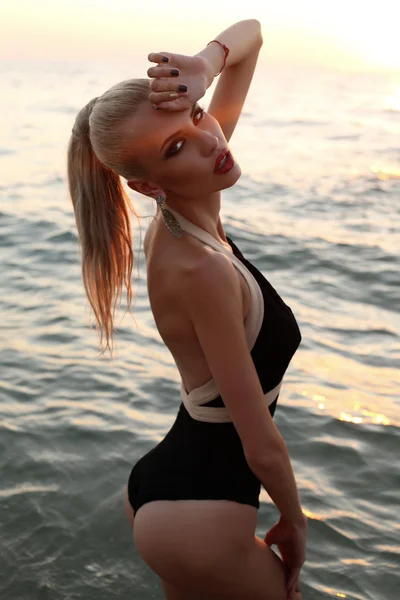 サンセット ビーチでリラックス、エレガントな水着でセクシーな女性 — ストック写真