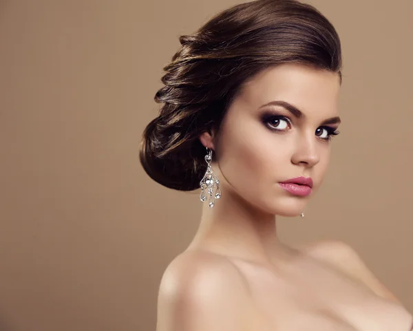 Vacker kvinna med mörkt hår och ljusa makeup, med bijou — Stockfoto
