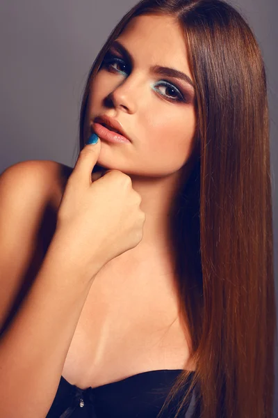 Mladá žena s rovnou tmavé vlasy a světlý make-up — Stock fotografie