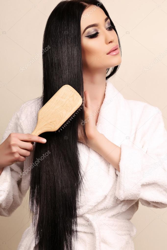 beautiful sensual woman combing her luxurious healthy hair 