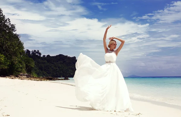 Beautiful bride in elegant wedding dress posing on tropical beach — Stock Photo, Image