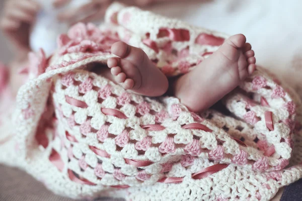 Foto de bonitos pés de bebê em acolhedor cobertor de malha — Fotografia de Stock