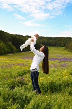 güzel anne onun küçük şirin bebek ile eğlenmek yaz bahçede   