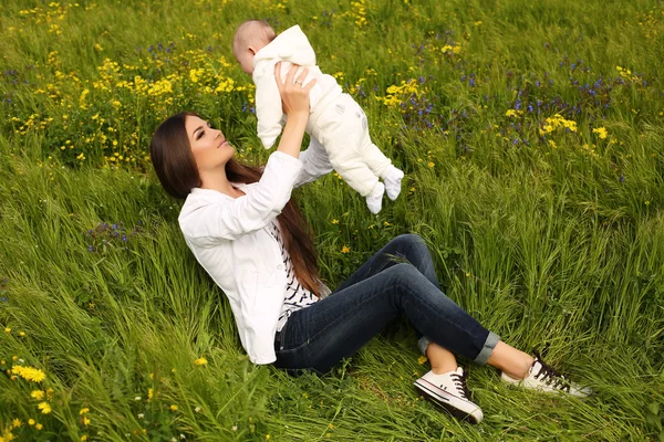 Mooie moeder plezier met haar kleine schattige baby in zomertuin — Stockfoto