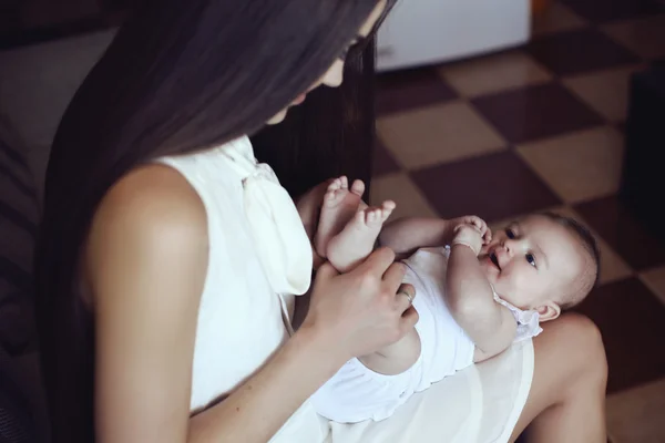 Schöne Mutter mit luxuriösen dunklen Haaren und ihrem kleinen Baby — Stockfoto