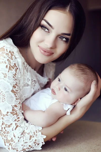 Bela mãe com cabelo escuro luxuoso e seu bebê pequeno — Fotografia de Stock