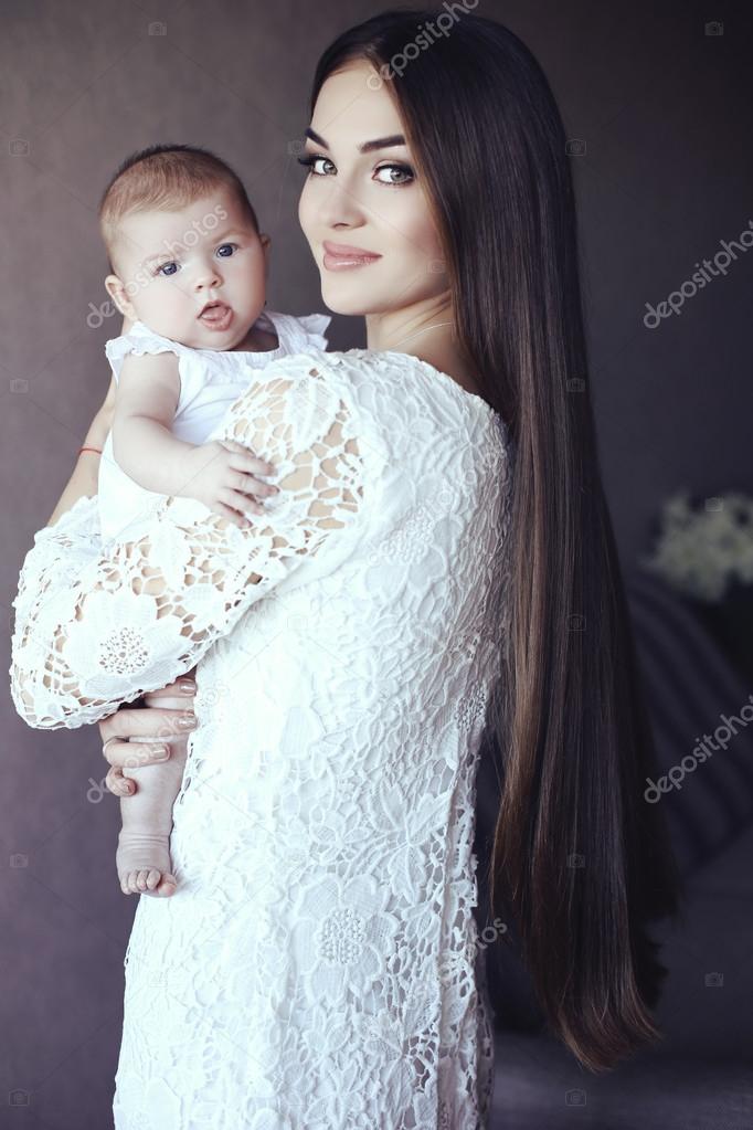beautiful mother with luxurious dark hair and her little baby   