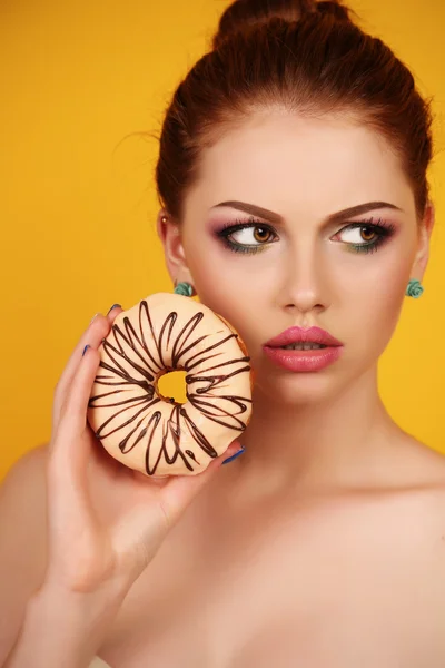 Jovem com cabelo escuro e maquiagem brilhante segurando donuts doces — Fotografia de Stock
