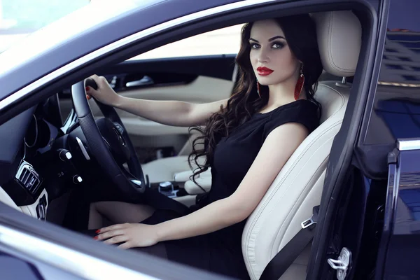 Hermosa mujer en vestido elegante posando en auto de lujo — Foto de Stock