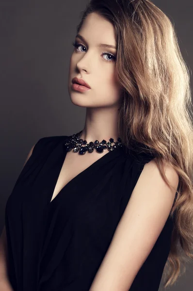 Όμορφη νεαρή κοπέλα σε κομψό μαύρο φόρεμα με bijou — Φωτογραφία Αρχείου
