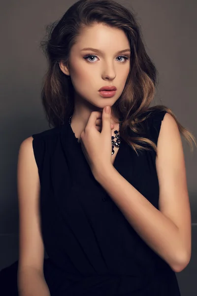 Vacker ung flicka i elegant svart klänning med bijou — Stockfoto