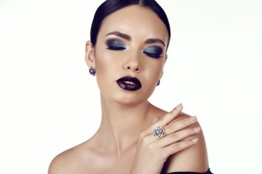 beautiful girl with dark hair with bright extravagant makeup and bijou  
