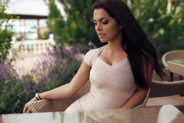 Hermosa mujer con el pelo oscuro usando vestido elegante, sentado en la cafetería de verano —  Fotos de Stock