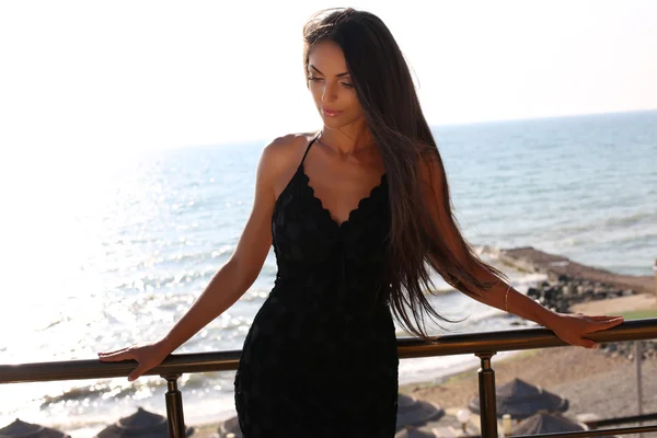 Mulher sensual com cabelo escuro em vestido preto elegante — Fotografia de Stock