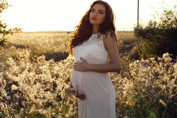 Krásná těhotná žena s tmavými vlasy v elegantní šaty — Stock fotografie