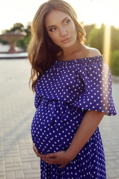 Beautiful pregnant woman  in elegant dress posing at summer park — Stock Photo, Image