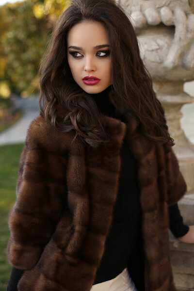 красивая женщина с темными волосами в роскошной шубе
  