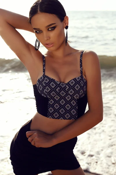 Sexig tjej med mörkt hår och solbränd hud poserar på stranden — Stockfoto