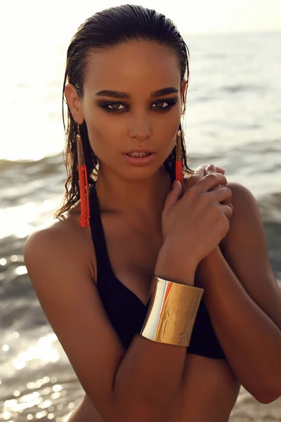 Sexy girl with dark hair and tanned skin posing on beach — Stock Photo, Image