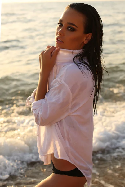 Menina sexy com cabelo escuro e pele bronzeada posando na praia — Fotografia de Stock
