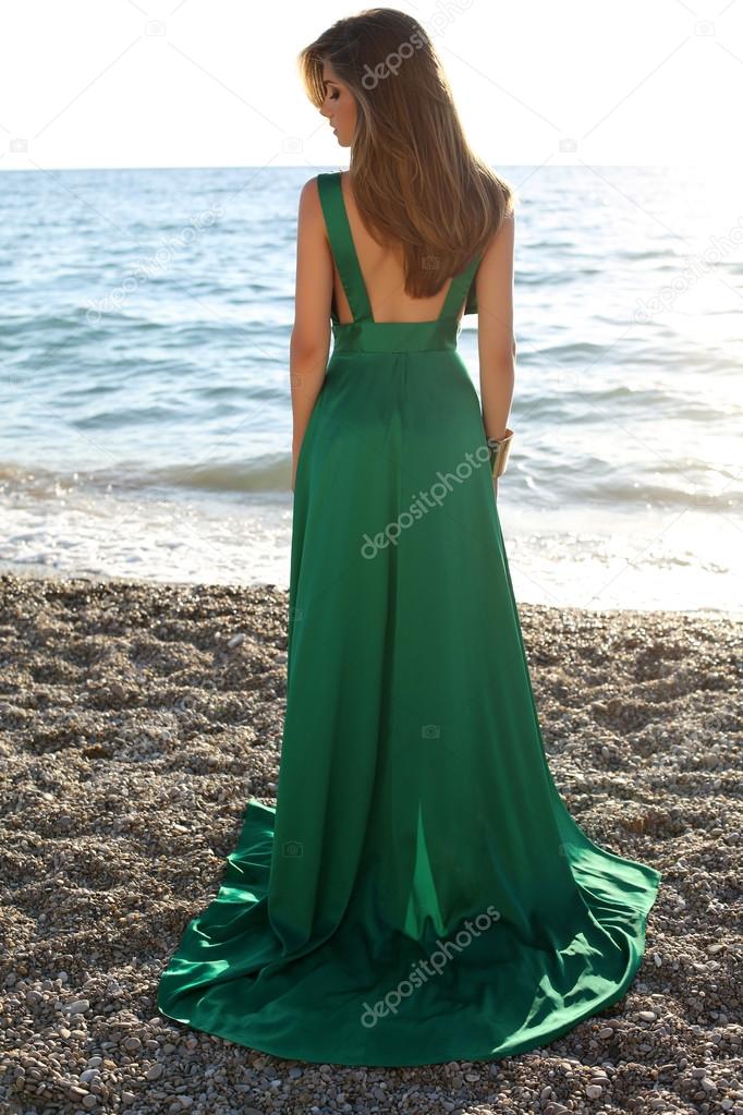 beautiful girl with blond hair wears luxurious green dress 