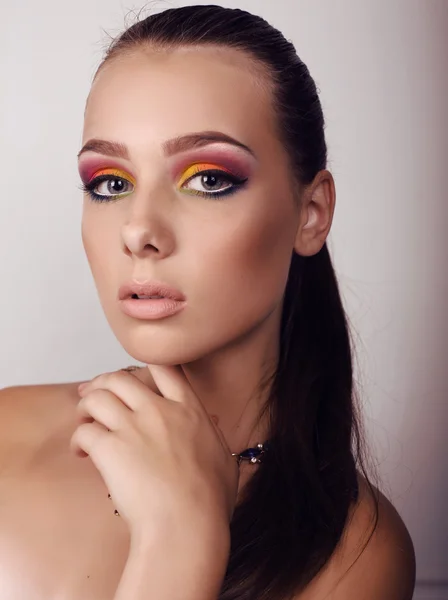 Vacker flicka med mörkt hår och extravaganta ljusa makeup — Stockfoto