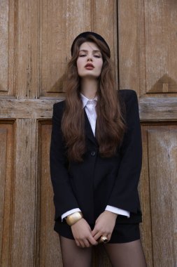 Uzun siyah saçlı, şık elbiseli, güzel, genç bir Slav kadının, sokakta poz verirken çekilmiş moda fotoğrafı.