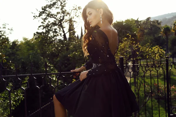 Beautiful woman with dark hair wears elegant dress — Stock Photo, Image