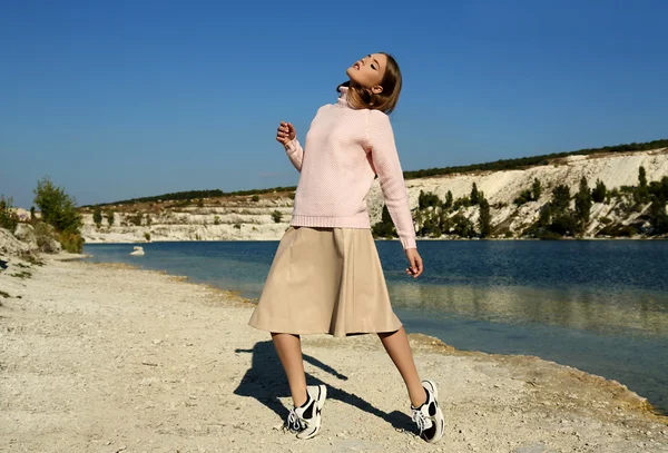 Beautiful woman in fashion clothes posing beside lake — Stock Photo, Image