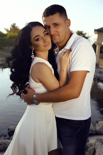 Beautiful sensual couple in elegant clothes posing in summer park — Stock Photo, Image