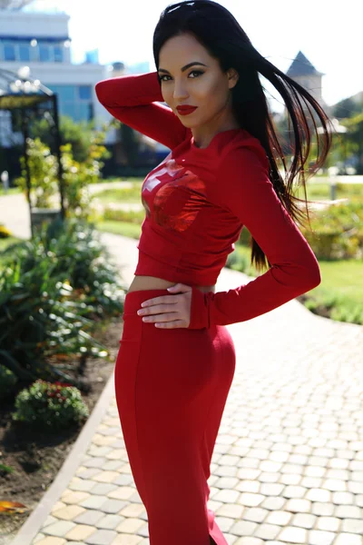 Sensual woman with long dark hair wears casual clothes, posing in summer park — Stock Photo, Image