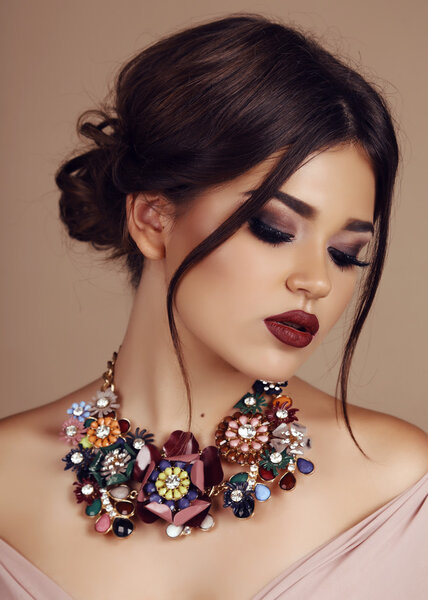 young woman with elegant hairstyle and luxurious necklace