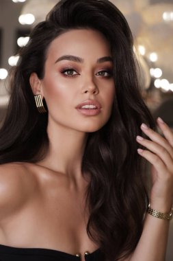 Stüdyoda poz veren siyah saçlı güzel bir kadının moda fotoğrafı.