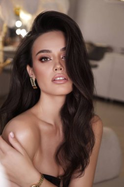 Stüdyoda poz veren siyah saçlı güzel bir kadının moda fotoğrafı.