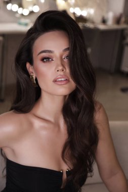 Stüdyoda poz veren siyah saçlı güzel bir kadının moda fotoğrafı.