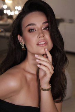 Stüdyoda poz veren siyah saçlı güzel bir kadının moda fotoğrafı.