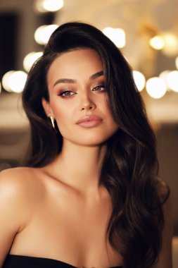 Stüdyoda poz veren siyah saçlı güzel bir kadının moda fotoğrafı.