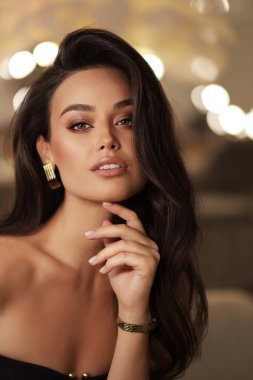 Stüdyoda poz veren siyah saçlı güzel bir kadının moda fotoğrafı.