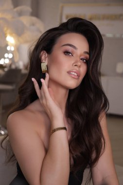 Stüdyoda poz veren siyah saçlı güzel bir kadının moda fotoğrafı.