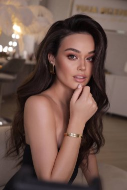 Stüdyoda poz veren siyah saçlı güzel bir kadının moda fotoğrafı.