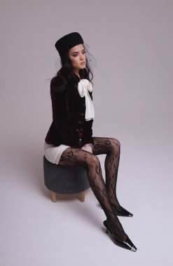 Güzel, seksi Slav bir kadının moda fotoğrafı. Koyu renk saçlı, lüks elbiseli, mücevherli.